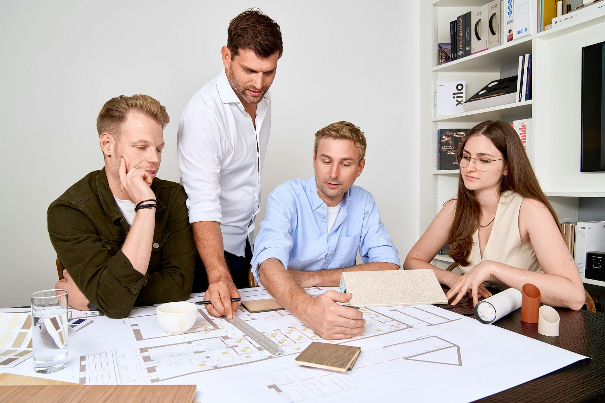 Das Team von VIERZUEINS DESIGN bespricht Pläne, Material- und Farbmuster im Büro