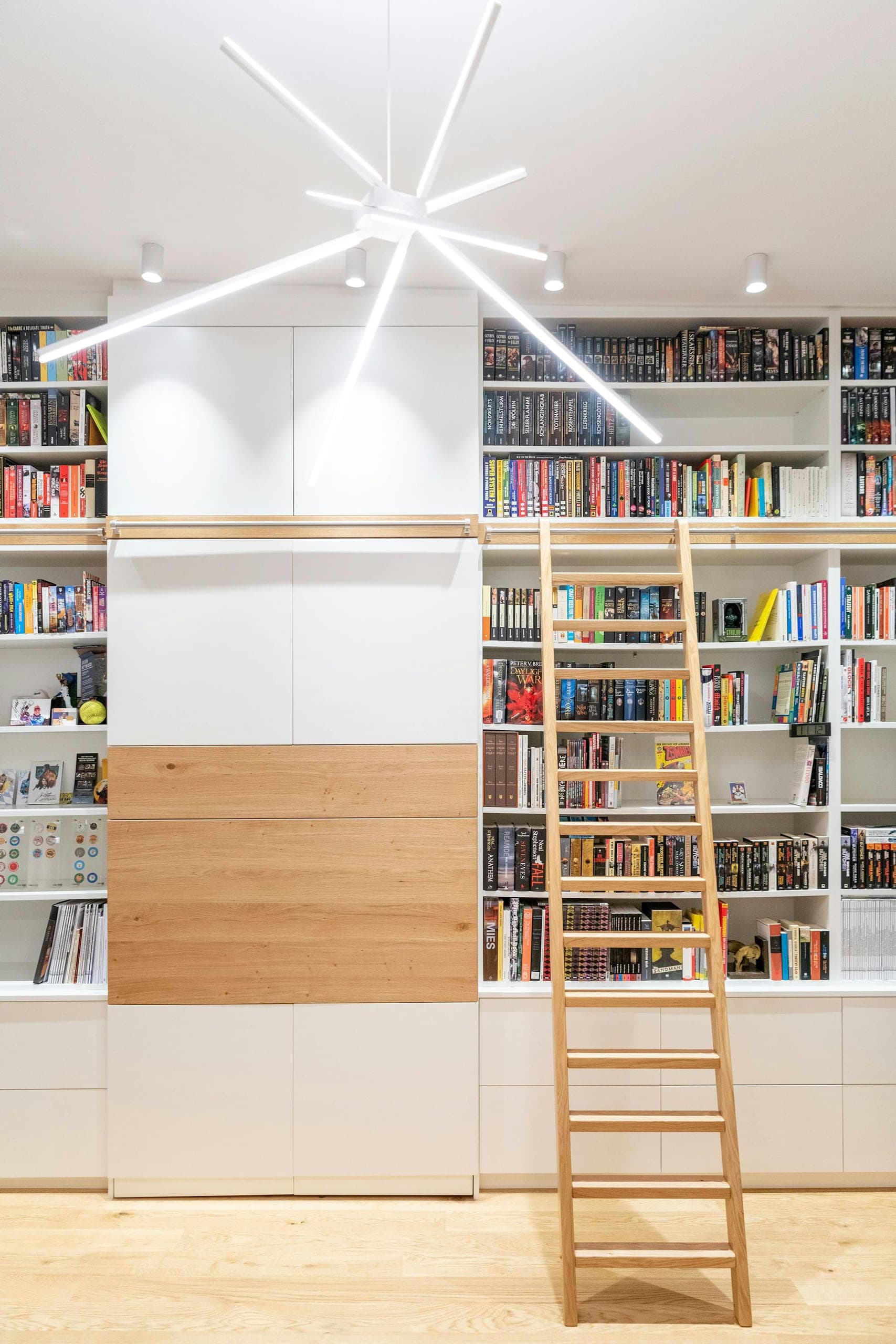 Die Höhe der Gründerzeiträume wird voll ausgenutzt, die Leiter ist Blickfang und Einladung, die Wohn-Bibliothek zu erlesen.